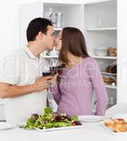 Cute couple kissing while having lunch in the kitchen