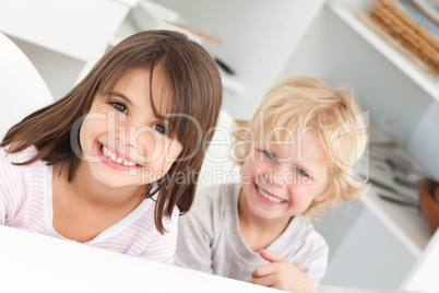 Happy children sitting at a table in the kitchen