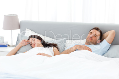 Serene couple sleeping on their bed in the morning