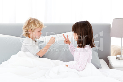 Cute brother and sister playing rock paper and scissors on their