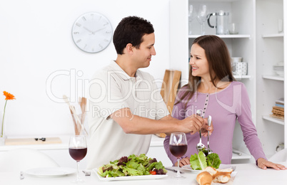 Attentive man serving salad to his girlfriend
