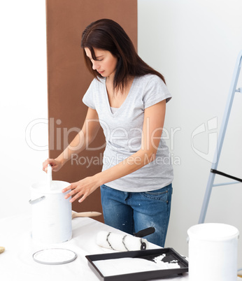 Pretty woman preparing white paint to renovate