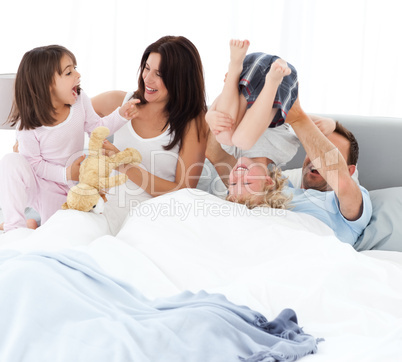 Happy family playing together on the bed