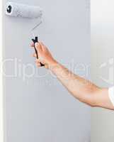 Close up of a man painting a wall in white
