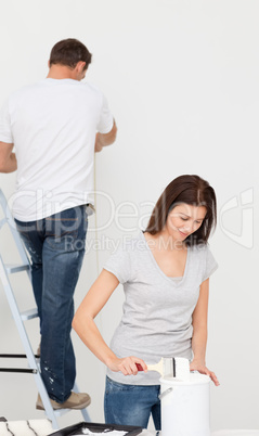 Happy couple painting together a room