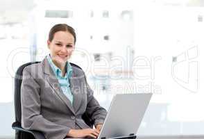 Young manager working on the laptop sitting at her desk