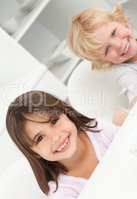 Cute brother and sister sitting at a table in the kitchen