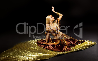 Young beauty woman lay on gold saber