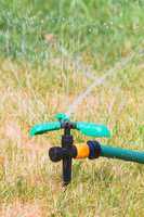 Close up of lawn sprinkler in summer day