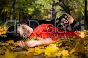 Young woman in autumn park on ground