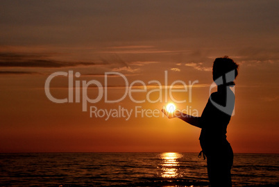 Silhouette holding sun
