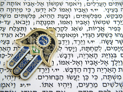 Blue Hamsa kabala good luck charm on Hebrew bible