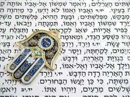 Blue Hamsa kabala good luck charm on Hebrew bible