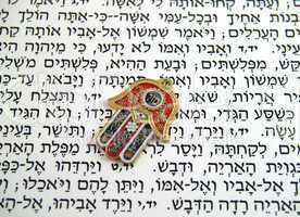 Red Hamsa kabala good luck charm on Hebrew bible