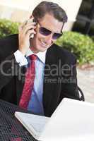 Businessman In Sunglasses Using Laptop Computer and Cell phone