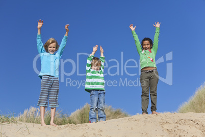 Three Children Arms Raised Having Fun on Beach