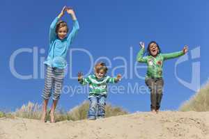 Three Children Arms Raised Jumping Having Fun on Beach