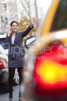 Young Woman on Cell Phone Hailing a Yellow Taxi Cab