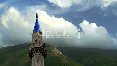 Timelapse clouds flowing past mosque minaret