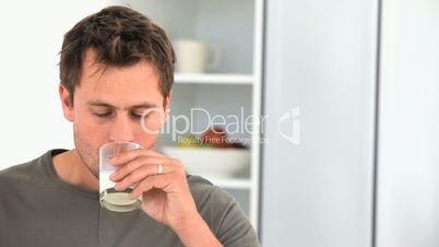 Mann trinkt aus einem Glas