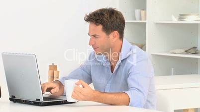 Mann mit Laptop und Kaffeetasse