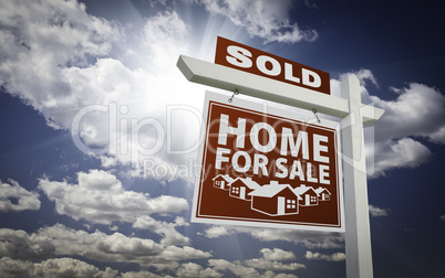 Red Sold Home For Sale Real Estate Sign Over Clouds and Sky