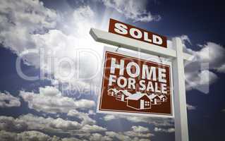 Red Sold Home For Sale Real Estate Sign Over Clouds and Sky