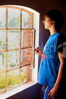 Junger Mann schaut aus dem Fenster 730