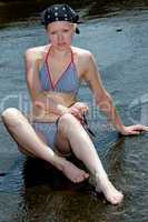 Junge Frau im Bikini sonnt sich am Wasser 910