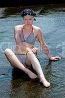 Frau im Bikini sonnt sich am Wasser 911