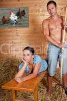 Junge Frau liegt auf einer Holzbank und der Jungbauer steht daneben 210