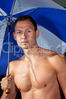 Junger Mann mit Regenschirm im Regen 361