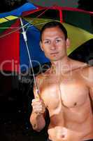 Junger Mann mit Regenschirm im Regen 364