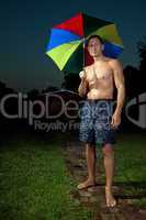 Junger Mann mit Regenschirm im Regen 366