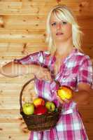 Junge blonde Frau mit Obstkorb reicht Apfel 236