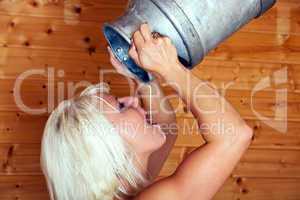 Junge blonde Frau trinkt aus Nilchkanne 260