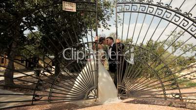 Pair of newlyweds is near the gate
