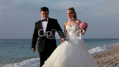 Newlyweds walking along the seashor