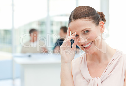 Smiling businesswoman looking at the camera while her coworkers