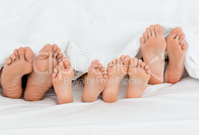 Family on the bed  at home with their feet showing