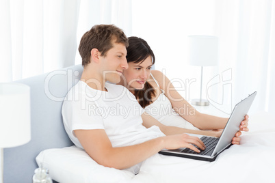 Young couple watching videos on their computer at home