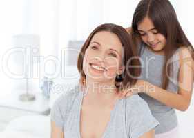 Lovely daughter brushing her woman hair