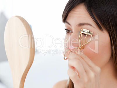 Woman curling her eyelashes