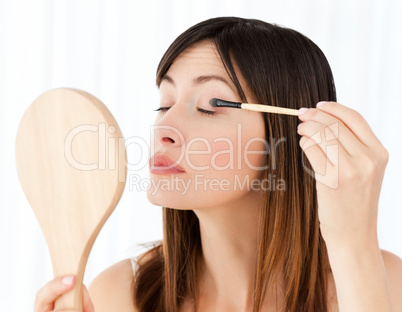 Beautiful woman putting on Make up