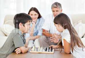 Parents looking their children playing chess
