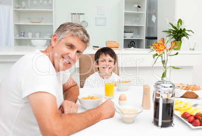 Father having his breakfast with his son