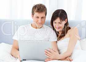 Young couple watching videos on their computer at home