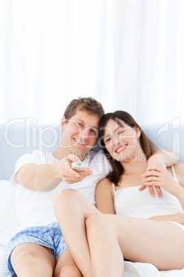 Smiling couple watching tv at home