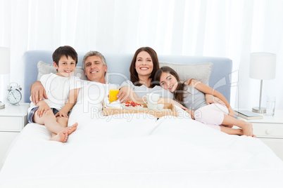 Family having breakfast in their bed