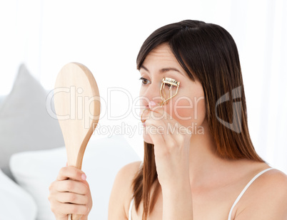 Woman curling her eyelashes